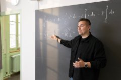 Mathematiklehrer Vinko T. steht vor einer Tafel und erklärt eine Formel.