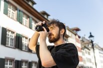 Mediamathiker-in: Mann mit Fotoapparat, der fotografiert