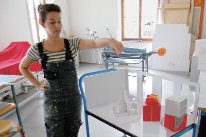 Polydesignerin 3D in Ausbildung bei der Arbeit mit Vitrinen und Podesten für das Museum der Kulturen.